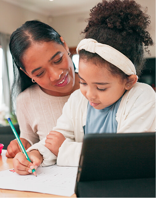 A parent sits beside a child, offering encouragement as they write on paper with Pobble Home open on a tablet nearby. A parent sits beside a child, offering encouragement as they write on paper with Pobble Home open on a tablet nearby.